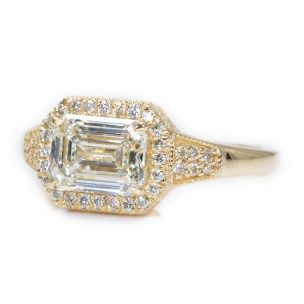 טבעת יהלום אמרלד מיוחדת וגדולה עם נוכחות מזהב צהוב שיבוץ יהלום לרוחב