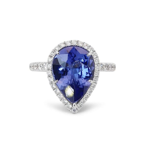 טבעת זהב לבן משובצת אבן חן טבעית טנזנייט מוקפת בהילת יהלומים קטנים.